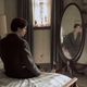 The Kid in Matthew’s suit, sitting on Matthew’s bed, looking in Matthew’s mirror.